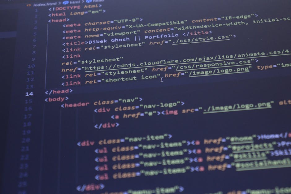 Photograph of a computer screen displaying HTML code with multicolored syntax highlighting, including tags such as <html>, <head>, <title>, and <body>. The code appears to be part of a website's struc